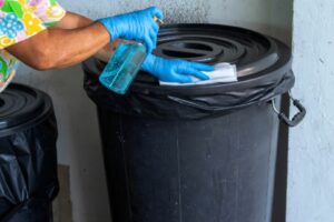 image of a person cleaning waste bins