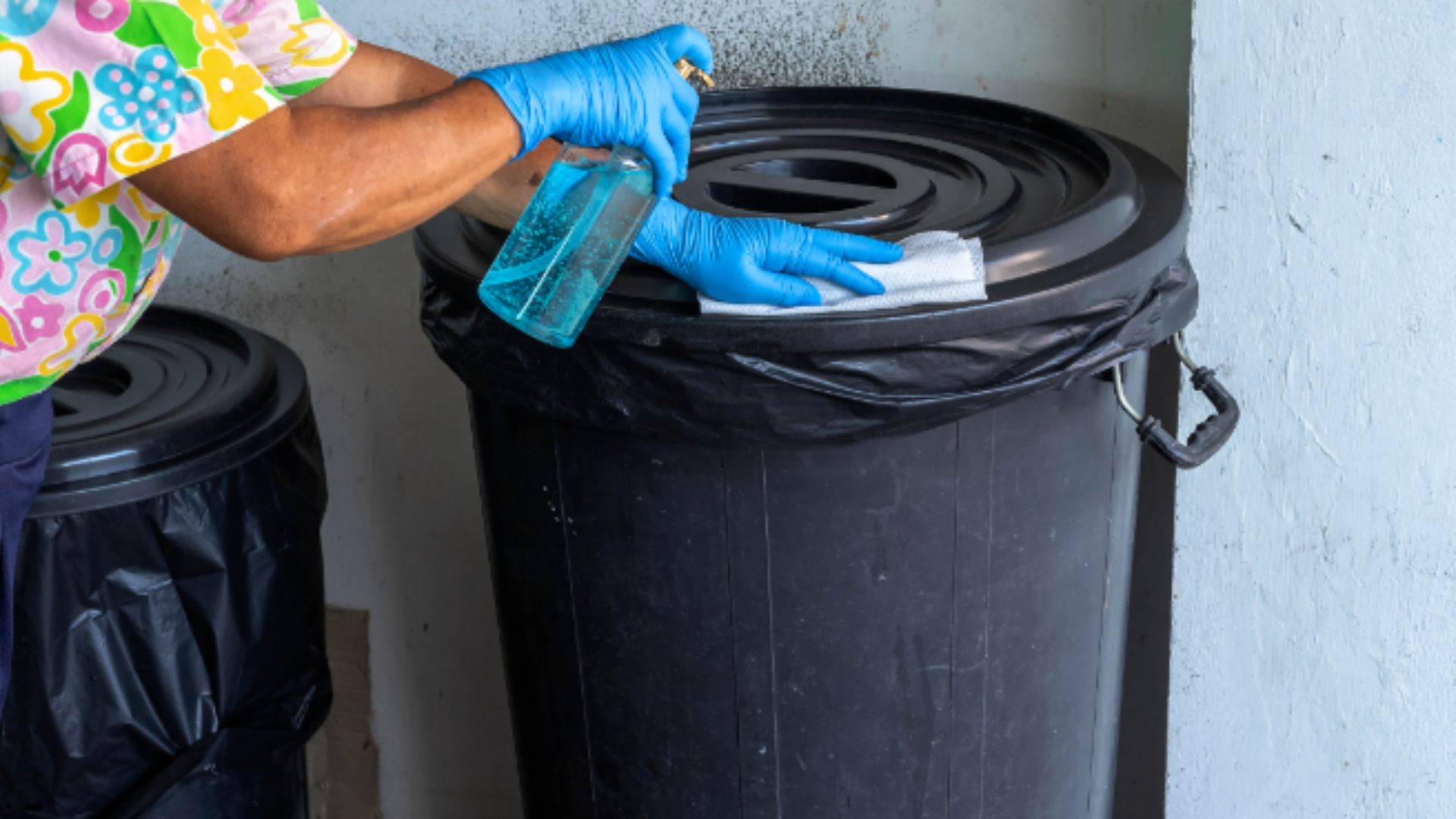 image of a person cleaning waste bins